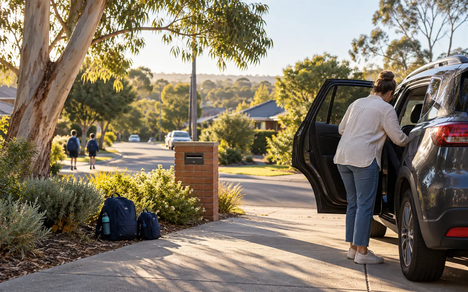 A parent getting the car ready in the driveway for the morning school run.